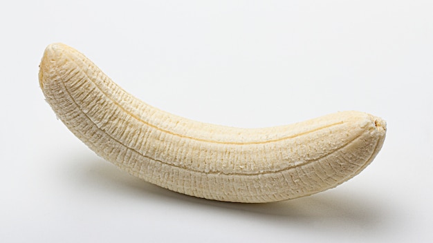 Premium Photo | Whole peeled banana on a white background