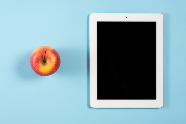 Download Free Whole Red Apple Near The Digital Tablet With Blank Screen On Blue Use our free logo maker to create a logo and build your brand. Put your logo on business cards, promotional products, or your website for brand visibility.