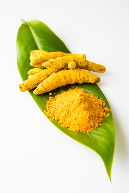 Premium Photo | Whole turmeric and haldi or huldi powder heap