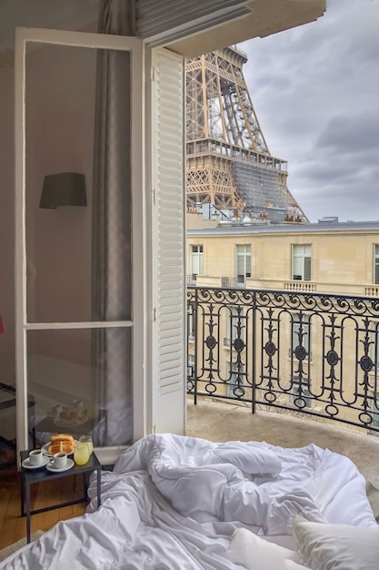 Premium Photo | Window view of the eiffel tower with breakfast in a bed