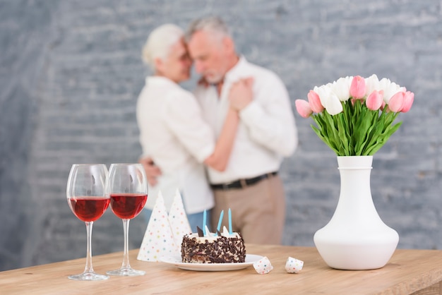 Wine Glass Party Hat Birthday Cake And Flower Vase On Table In