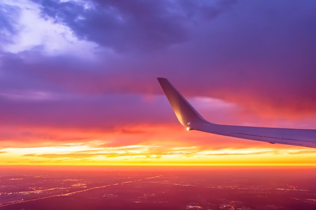 Wing of the plane lit by the sunset Premium Photo