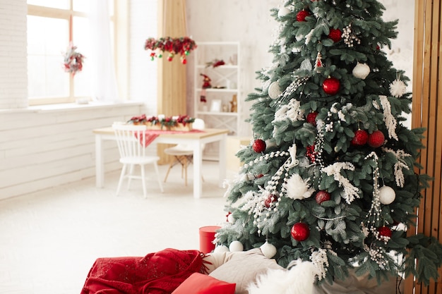 Winter holidays decor. rich decorated new year tree stands with present boxes Free Photo