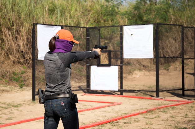 Premium Photo | Woman aiming pistol in shooting range