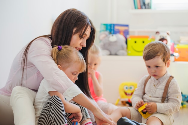 Woman and children sitting on floor Free Photo