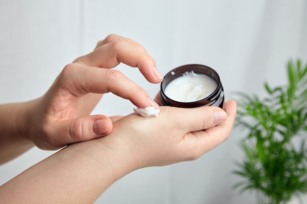 Woman applying moisturizer to her skin of hand Premium Photo