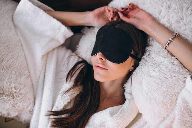 Woman in bed wearing sleeping mask Free Photo