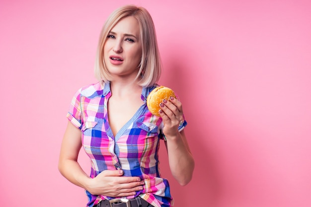 Premium Photo | Woman blonde perfect skin eating burger holds hand on ...