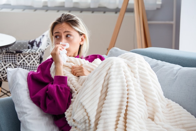 Premium Photo | Woman caught cold and flu sneezing into tissue.