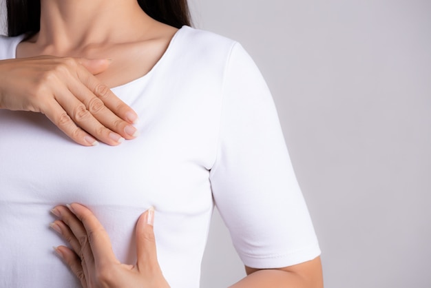 Woman checking lumps on her breast for signs of breast cancer. Premium Photo
