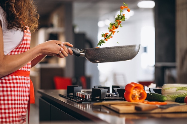 Woman chef cooking vegetables in pan Free Photo