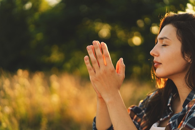 Premium Photo | Woman closed her eyes praying in a field during ...