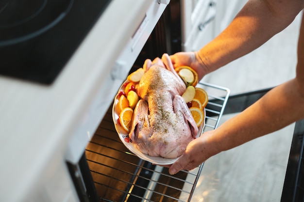 Free Photo | Woman cooking christmas duck puting raw duck with
