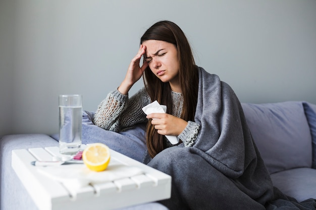 Woman on couch with medication Free Photo