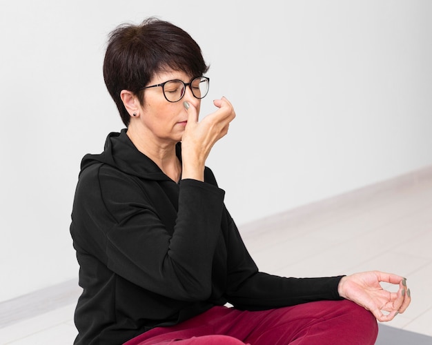 Free Photo | Woman covering a nostril while meditating