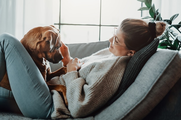 Premium Photo | Woman cuddles plays with her dog at home