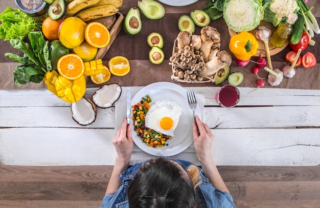 Premium Photo | The woman at the dinner table with organic food , the ...