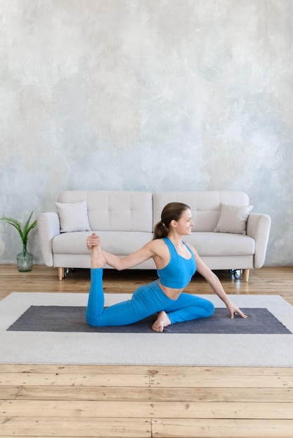 Premium Photo | Woman doing morning yoga exercises at home on the mat