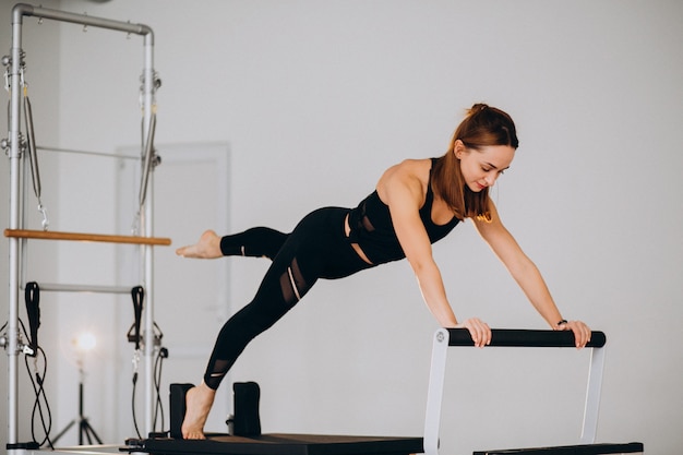 Woman doing pilates on a reformer Free Photo