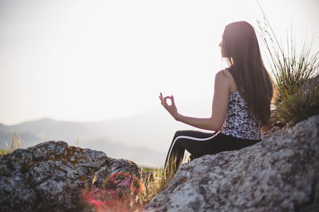 Free Photo | Woman doing yoga on stone