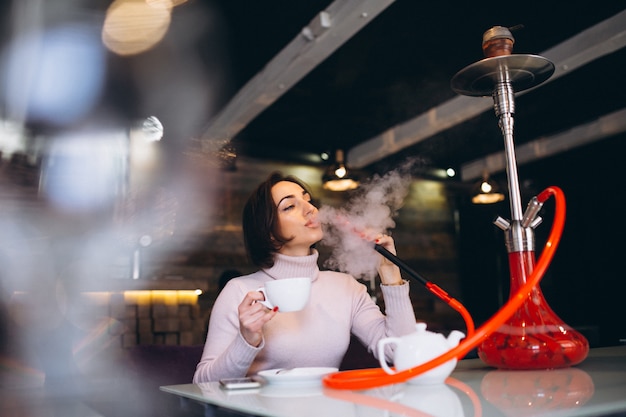 Premium Photo Woman Drinking Tea And Smoking Shisha