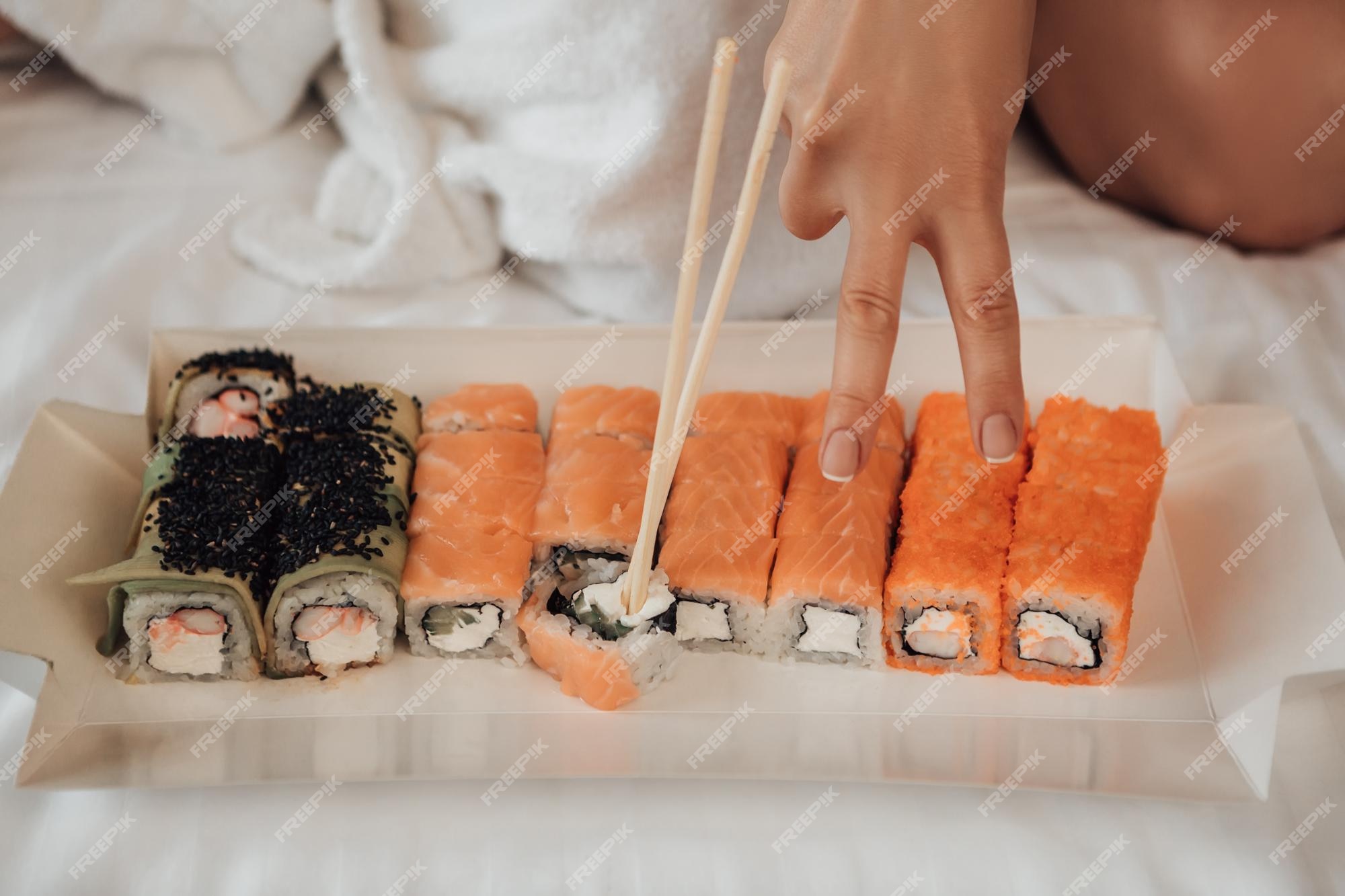 premium-photo-woman-eat-sushi-in-bed