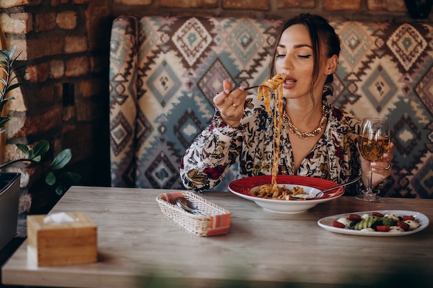 イタリアンレストランでパスタを食べる女性 無料の写真