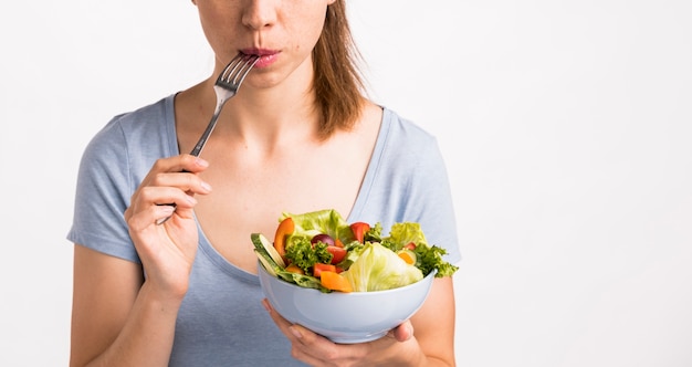 Woman eating a salad with a fork Free Photo