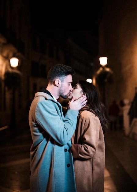 夜に遊歩道に若い男と抱きしめてキスする女性 無料の写真