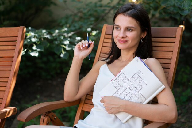 Free Photo Woman Enjoying A Sudoku Game On Paper By Herself