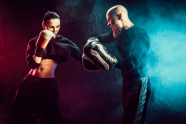 Premium Photo | Woman exercising with trainer at boxing and self ...