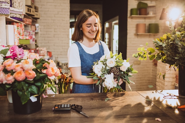 Free Photo | Woman florist at her own floral shop taking care of flowers