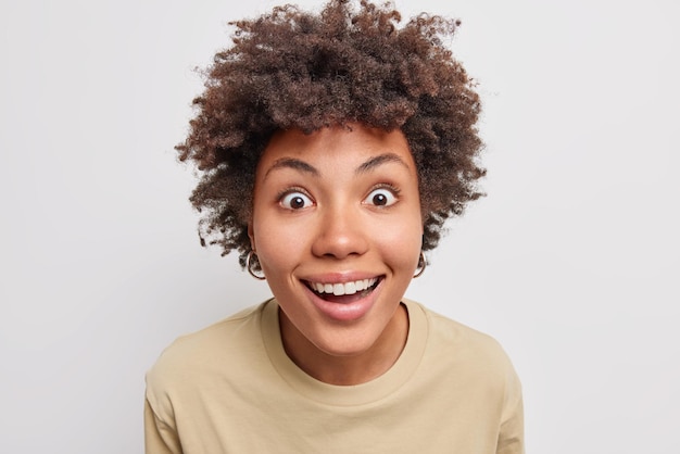 Premium Photo | Woman gazes with happy surprised expression smiles ...