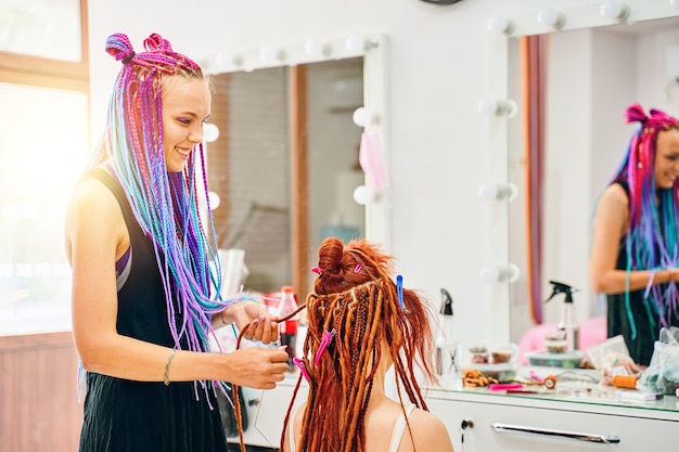 Premium Photo | Woman hairdresser with colored afro braids weaves to ...