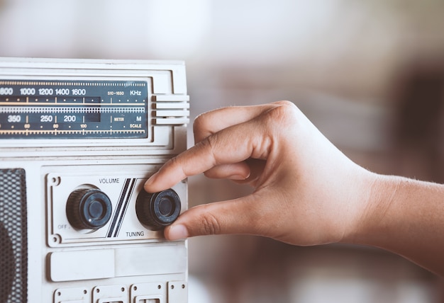 Premium Photo | Woman hand adjusting the sound volume on retro radio