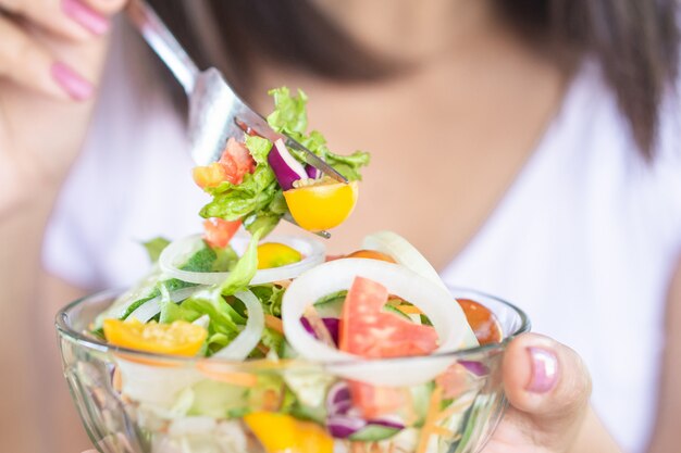 Woman hand eating healthy salad Premium Photo