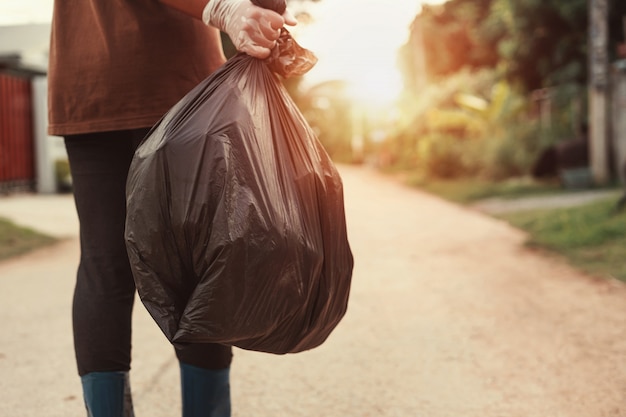 Premium Photo | Woman hand holding garbage bag for recycle putting in ...