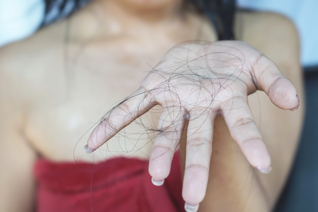 Premium Photo | Woman hand holding her hair loss while taking a shower