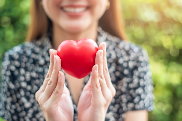 Woman hand is holding red heart Premium Photo