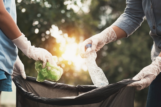 Woman hand picking up garbage plastic for cleaning at park | Premium Photo