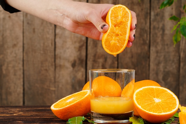 女性の手がオレンジジュースを絞る プレミアム写真