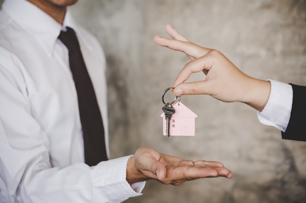Premium Photo | Woman handing over the house keys to a new home inside