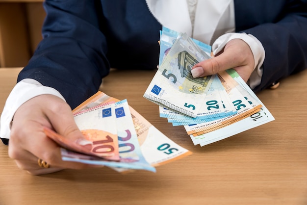 Premium Photo | Woman hands giving euro banknotes