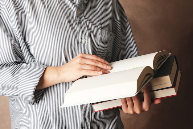 Premium Photo | Woman holding books against brown background, close up