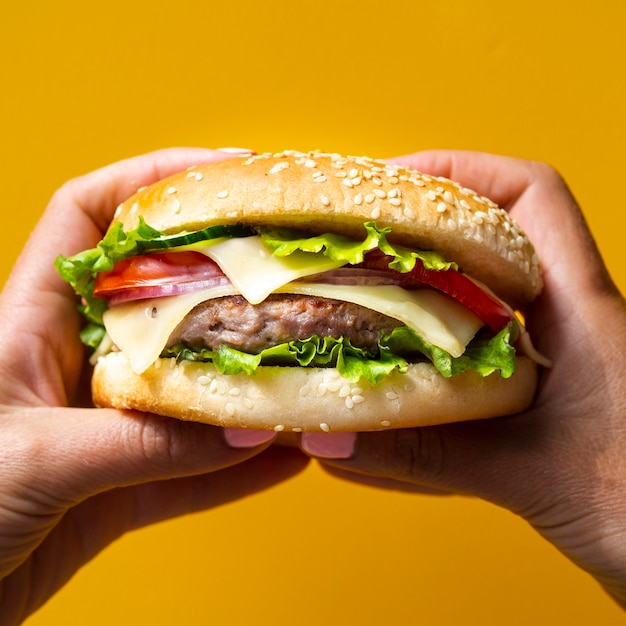 Woman holding a burger with both hands | Free Photo