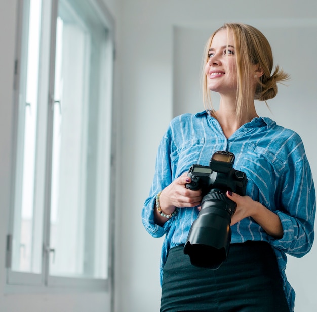 Free Photo | Woman holding a camera and looking through windows