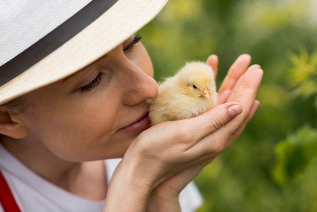 Woman holding a chick on a farm | Free Photo