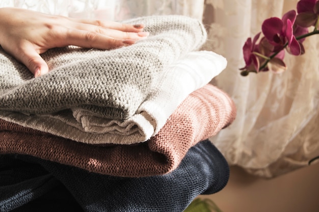 Premium Photo | Woman holding folded clothes in hands