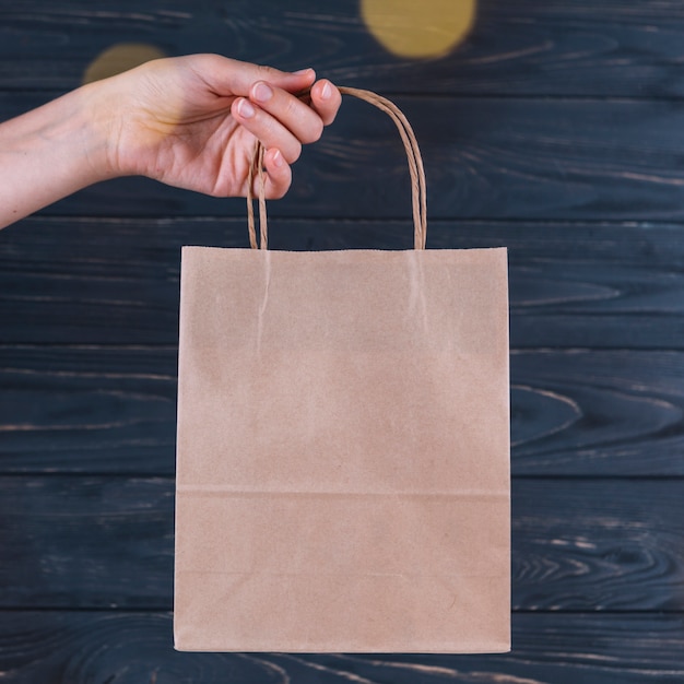 Download Woman holding gift bag in hand | Free Photo