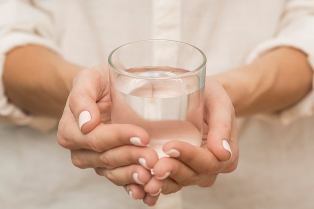 Woman holding a glass filled with water Free Photo